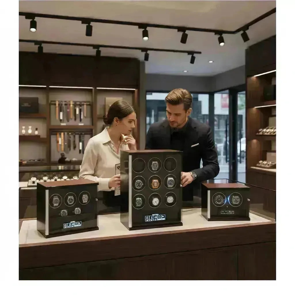 Couple examining luxury watch winders in a modern boutique, showcasing various styles and capacities.