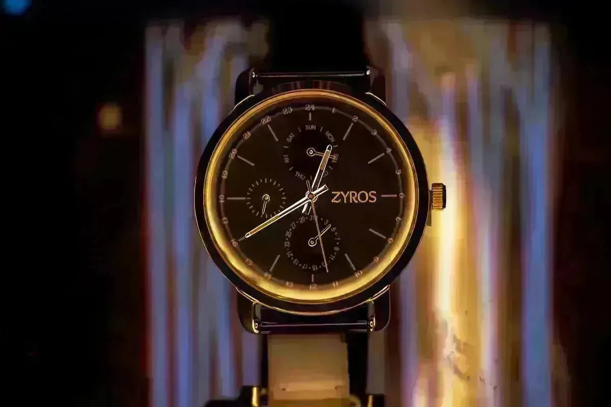 Elegant Zyros watch with a gold-rimmed black dial and intricate sub-dials displayed against a warm, glowing background.