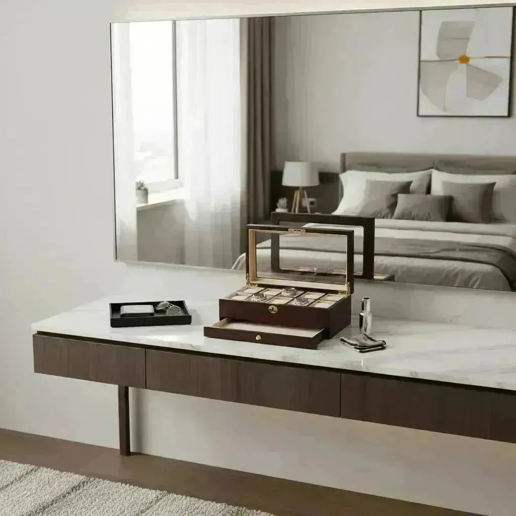 Elegant dark wood Tempus watch box with glass top on a marble vanity, reflecting a modern bedroom.