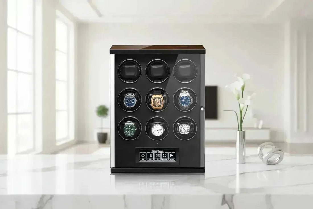 A sleek, black and wood watch winder with nine slots, holding six luxury watches, on a marble surface.