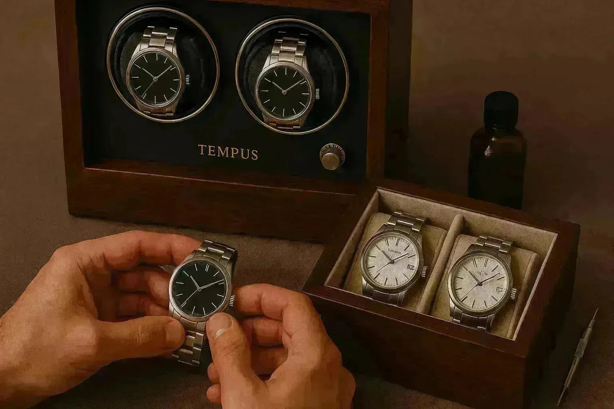 A wooden Tempus watch winder displaying two black-dial watches next to a storage box holding two silver-dial timepieces.