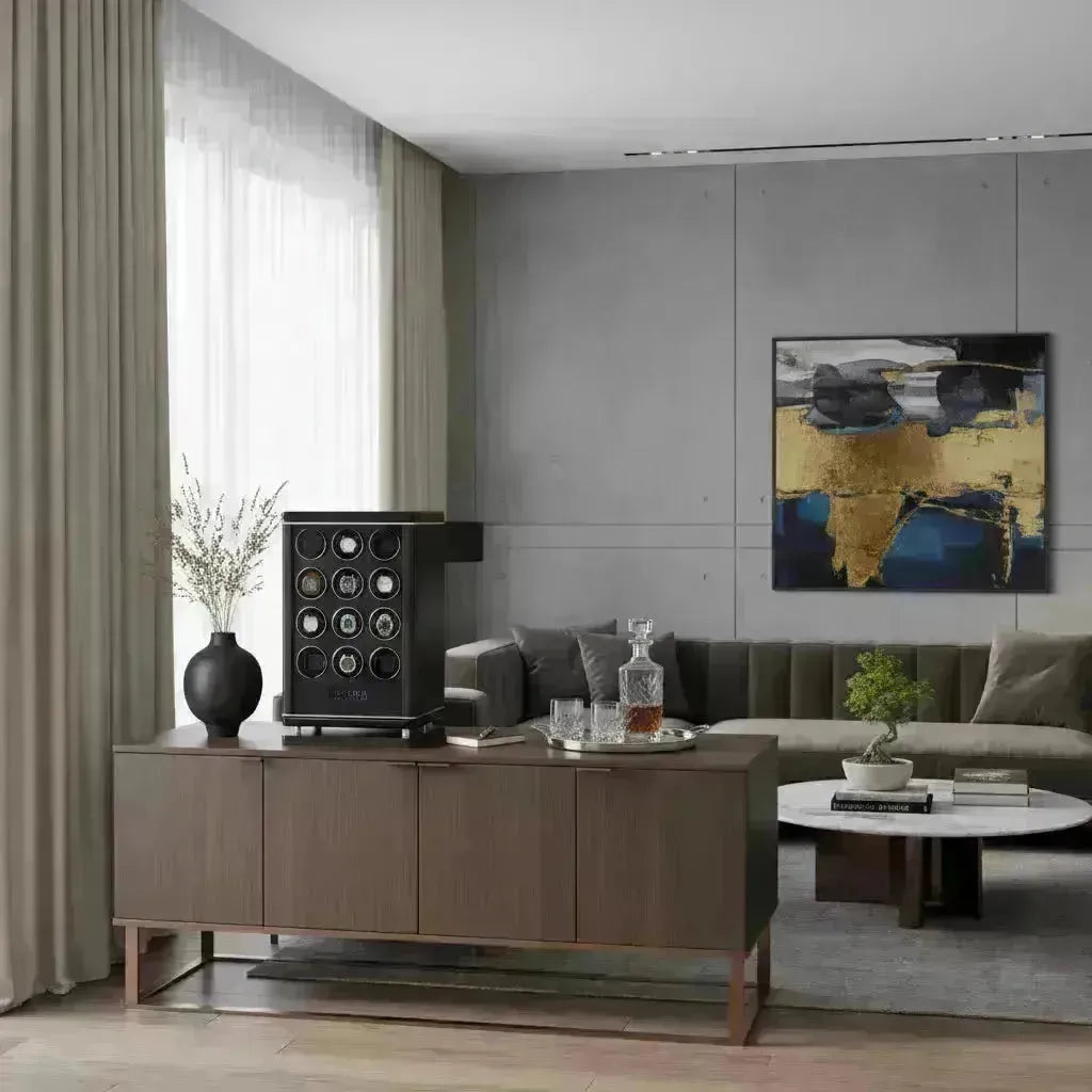 Black multi-watch winder on a dark wood credenza in a modern living room with abstract art.