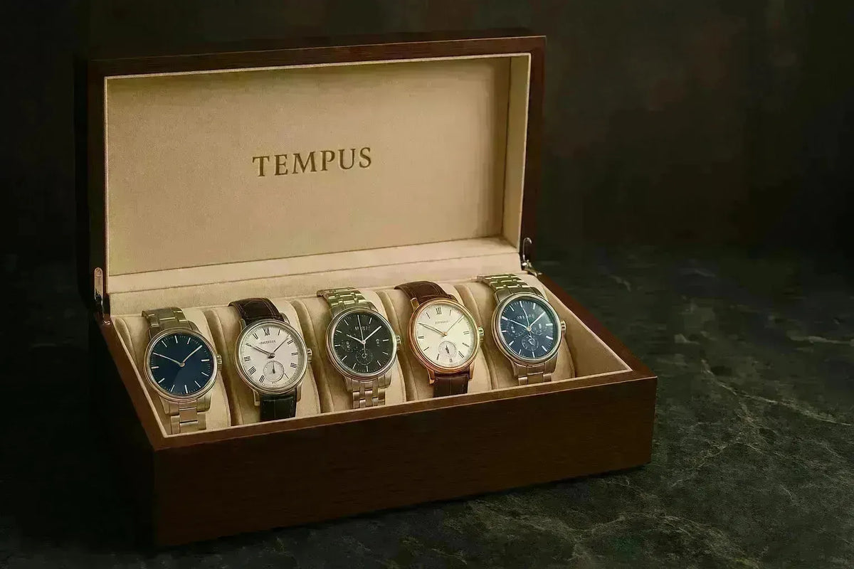 A premium wooden Tempus watch box displaying five luxury wristwatches on a soft beige interior lining.