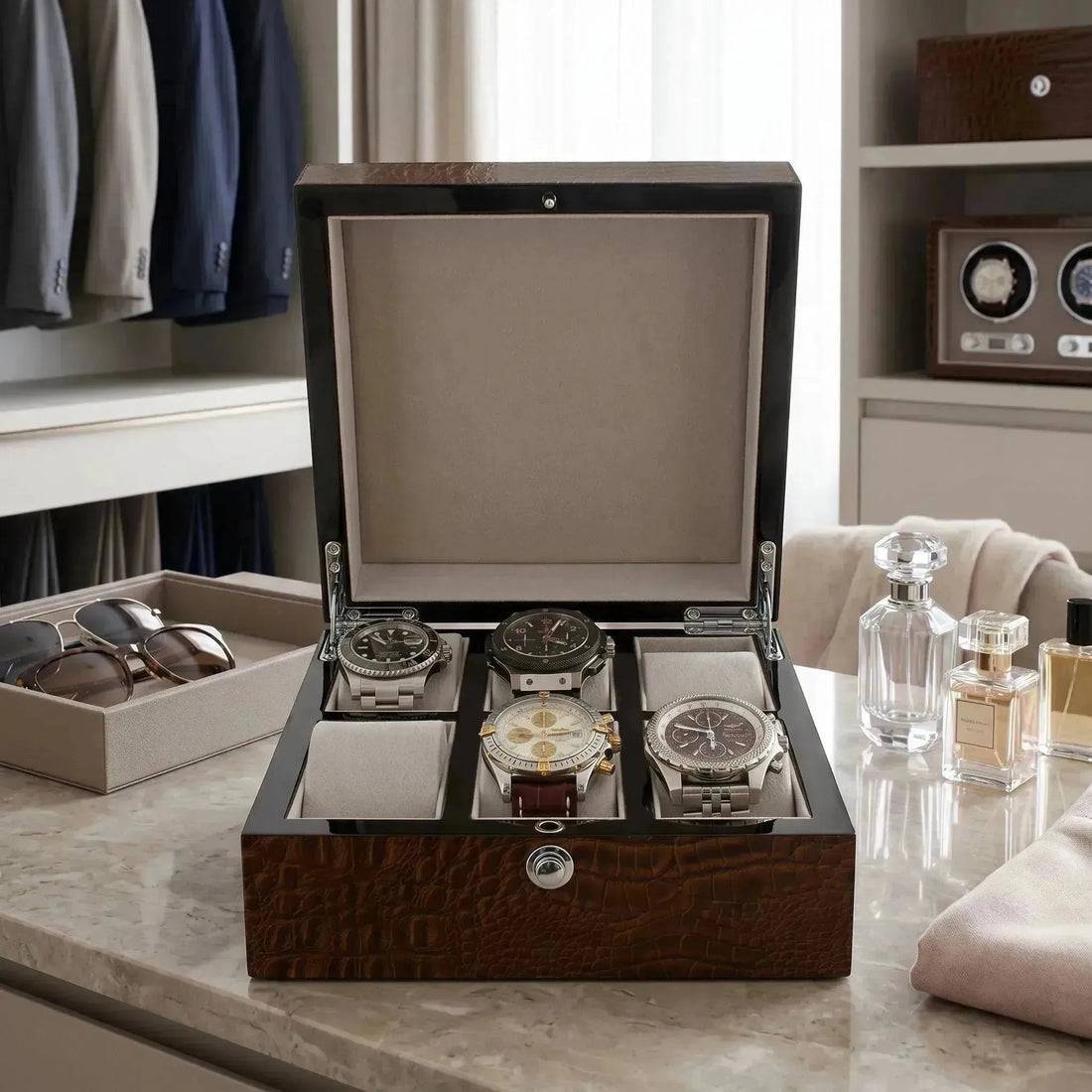 Open dark wood watch box with five luxury Breitling watches on a marble surface.