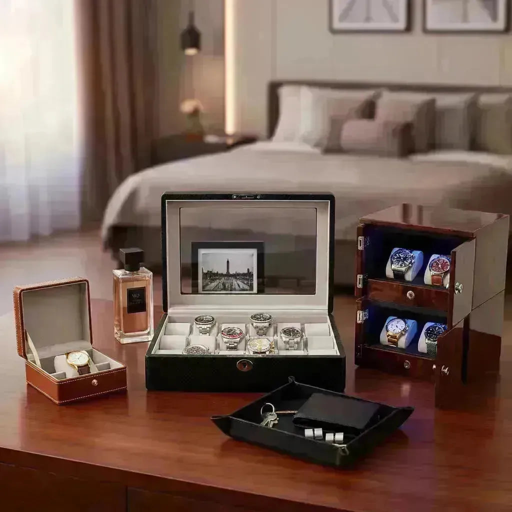 Luxurious watch boxes: a black carbon fiber display case, a brown leather single watch box, and a stacked wooden winder.