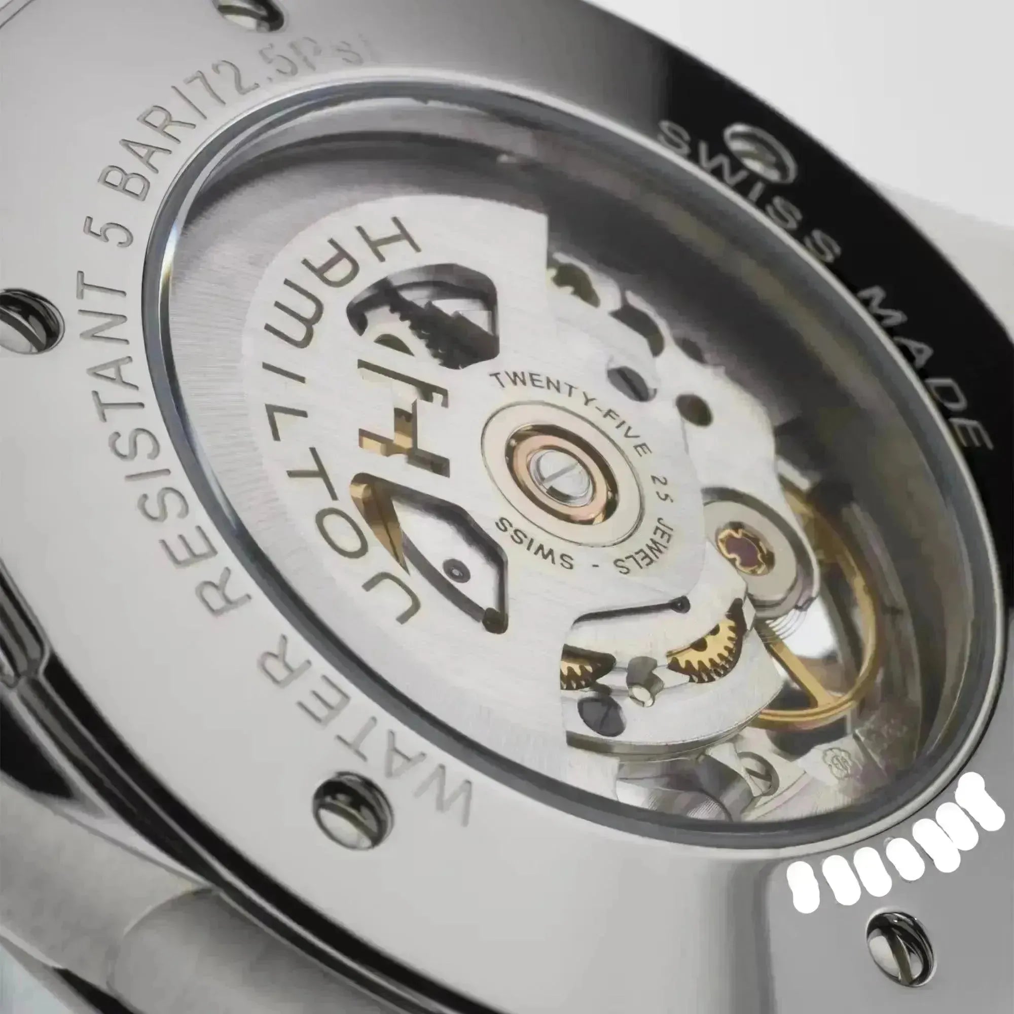 Close-up of a Hamilton automatic watch movement with visible gears and rotor through the clear case back.