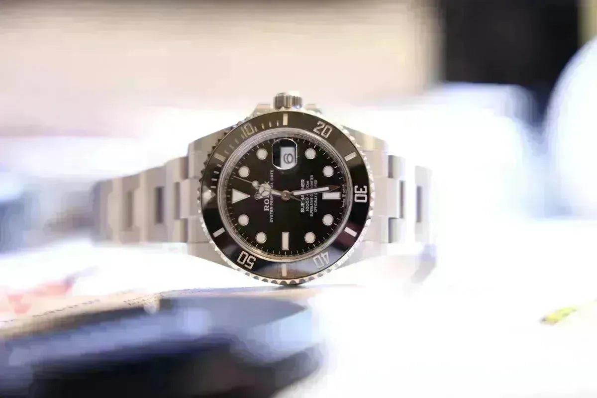 Close-up of a classic silver analog watch with a black face and date display.