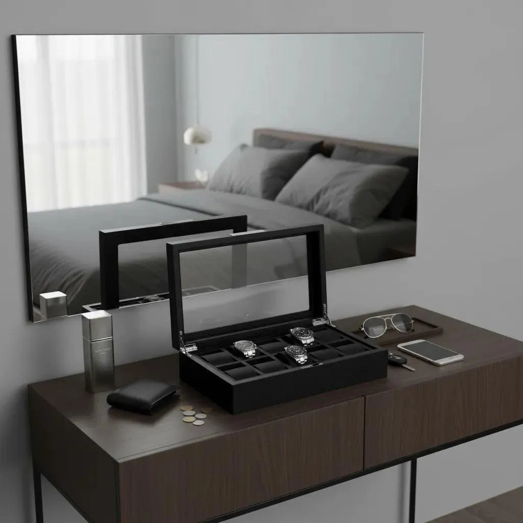 A modern bedroom vanity with a large mirror reflects a neatly made bed. On the oak veneer surface is the Tempus Luxury Watch Winders 10 Watch Box Premium Black Oak Veneer, along with a wallet, coins, sunglasses, smartphone, and silver spray bottle.