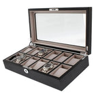 The Tempus Luxury Watch Winders 12 Watch Box features a premium black oak veneer, glass lid, beige interior, and compartments for luxury watches—shown with three silver wristwatches beside several empty slots.