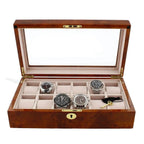 The Aevitas Watch Box for 12 Wrist Watches in Burl Walnut Wood has a glass lid, beige interior, and twelve compartments, offering premium storage for your collection. Most compartments are empty to showcase its spacious design.