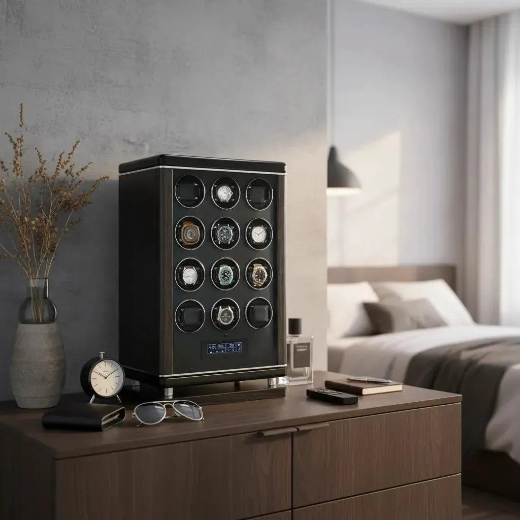The Tempus Luxury Watch Winders 12 Watch Winder for Automatic Watches with BioMetric Technology sits on a wooden dresser in a modern bedroom, displaying twelve watches amid a clock, sunglasses, and perfume. A bed and curtained window are behind.