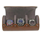 Triple Watch Roll features vintage brown leather and a super soft grey suede lining, holding three silver wristwatches with red/blue, blue, and black faces for a stylish display.