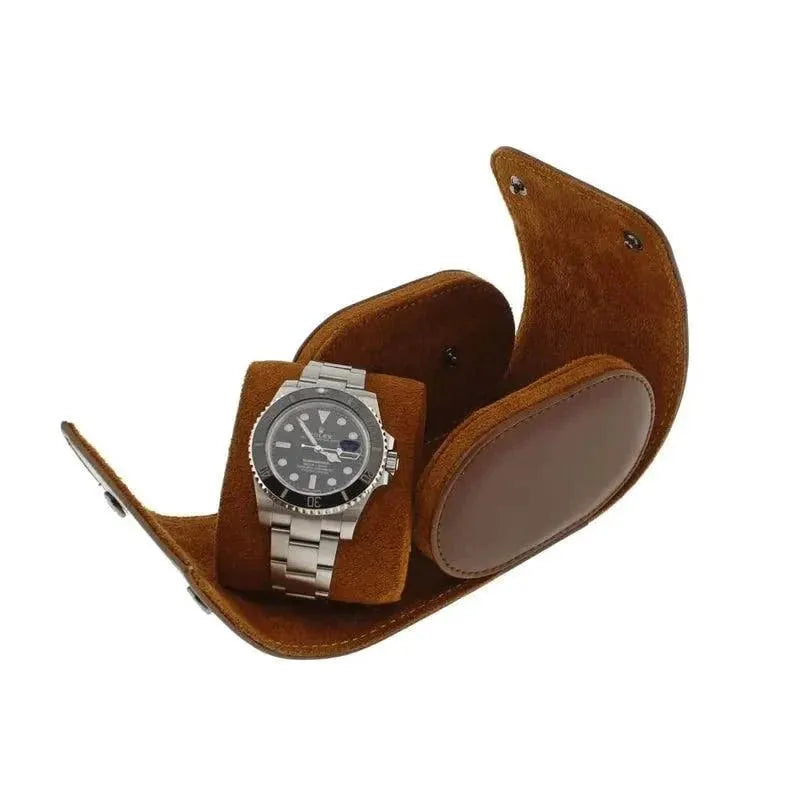 A silver wristwatch with a black dial rests on the Aevitas Premium Single Watch Roll in brown leather and super soft tan suede lining, shown against a white background.