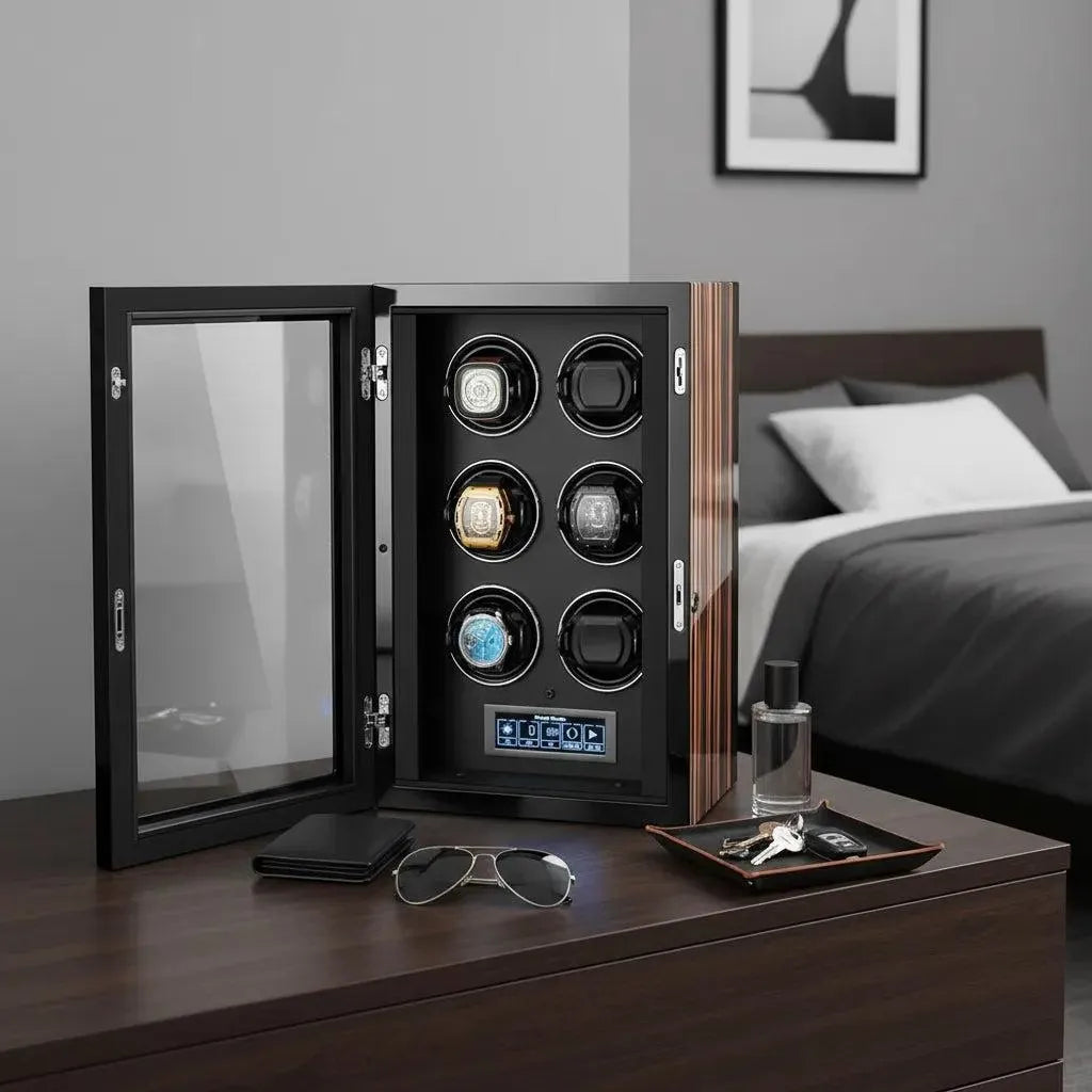 The Tempus 6 Watch Winder for Automatic Watches by Tempus Luxury Watch Winders, with four wristwatches inside, sits open on a bedside table alongside sunglasses, a wallet, tray with keys, watch, pen, and cologne. A bed and artwork are in the background.