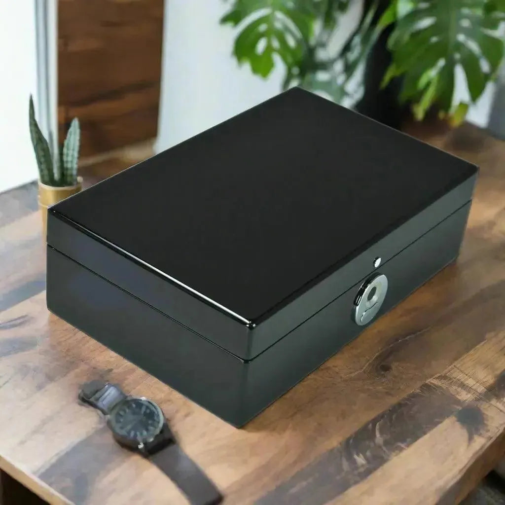 The Tempus 8 Watch Box in Black Piano Finish with Bio Metric Lock by Tempus Luxury Watch Winders rests on a wooden table, accompanied by a luxury watch and a small potted cactus, with lush green plants in the background.