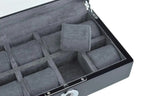The Tempus Luxury Watch Winders Tempus 8 Watch Box in Black Piano Finish features a biometric lock, glass lid, and gray cushioned compartments—one cushion lifted to reveal organized watch storage.