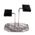 The Tempus Double White Marble Watch Stand by Tempus Luxury Watch Winders features dark violet veins and two metal rods with black leather pads—ideal for stylishly displaying your watches or bracelets.