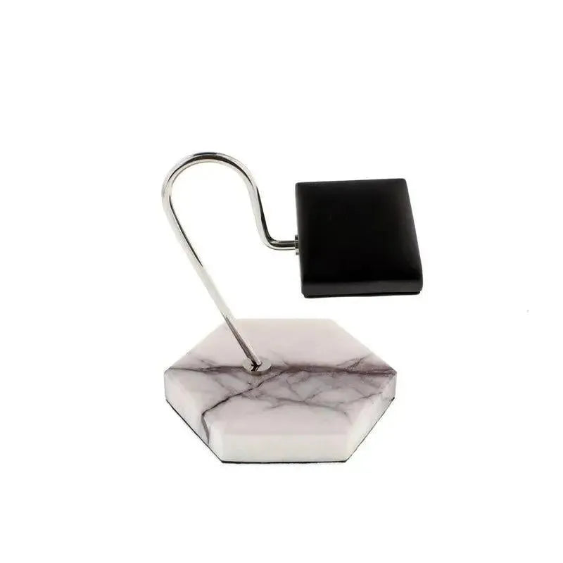 Inspired by the elegant Tempus White Marble Watch Stand with dark violet veins and black leather by Tempus Luxury Watch Winders, this modern razor stand features a hexagonal marble base, curved metal arm, and sleek black holder.
