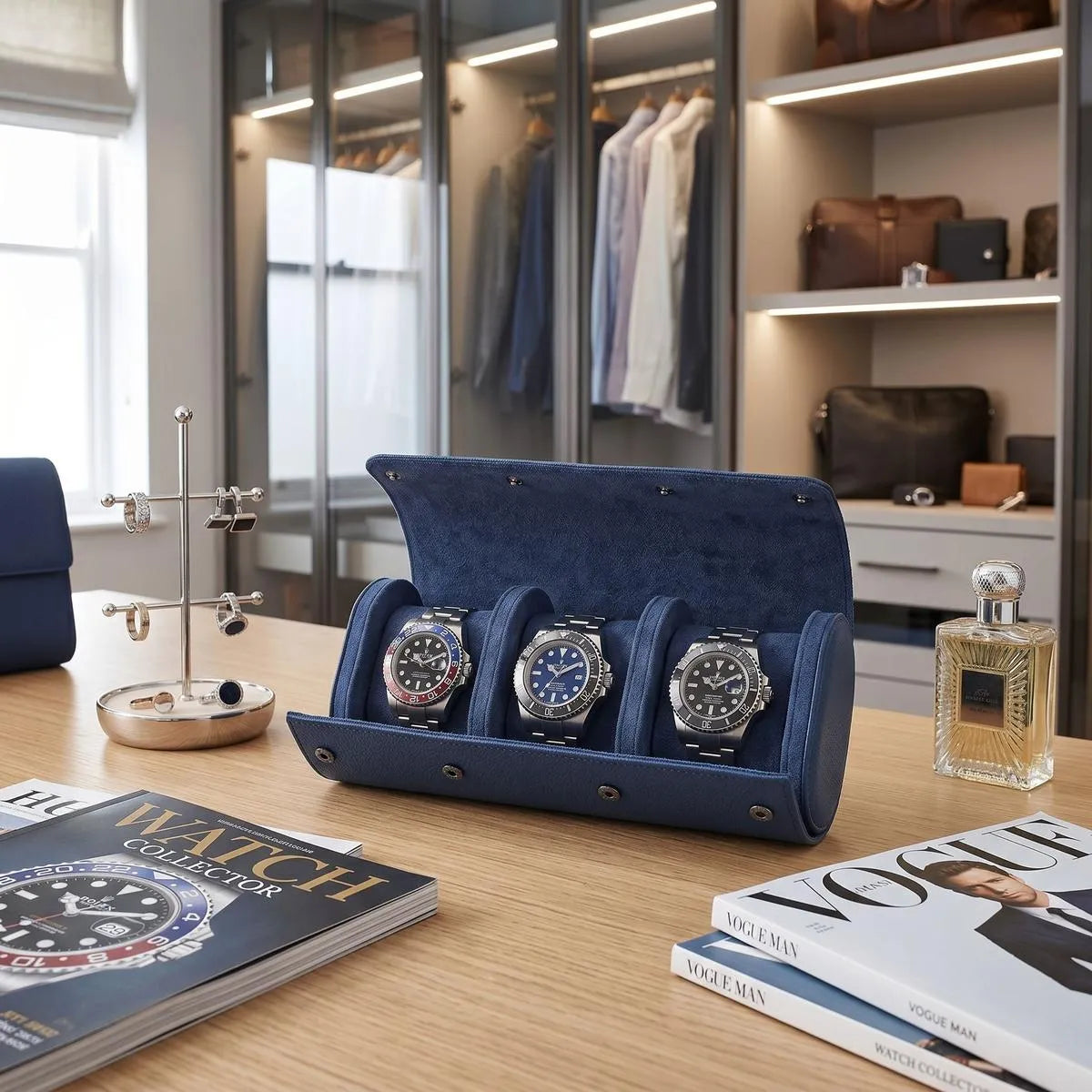 Full-front view of blue vegan leather watch roll displayed on a polished wooden vanity with stylish props in a bright modern dressing room.