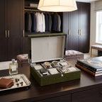 Full front view of sleek green crocodile print watch box in luxurious dressing room, showcasing compact design and high-gloss finish.