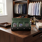 Full-body shot of watch roll on a plush dressing room bench with accessories, highlighting its carbon fibre finish and green interior in a modern luxurious setting.
