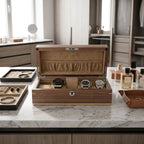 Frontal view of light walnut wood watch box with watches in compartments on polished surface in elegant dressing room.