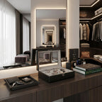 Front view of an 18-watch carbon fibre leather watch box in a bright, modern walk-in dressing room surrounded by elegant accessories.