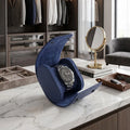 Premium blue vegan leather watch roll with suede lining displayed in a bright, modern walk-in closet with luxury props.