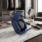 Premium blue vegan leather watch roll with suede lining displayed in a bright, modern walk-in closet with luxury props.