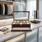 Close-up front view of a cherry wood watch box with satin finish in a modern dressing room, highlighting cushioned watch slots and elegant texture.