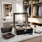 Close-up of a 6-watch black gloss finish box with grey lining in a modern dressing room on marble countertop