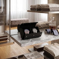Close-up of premium black vegan saffiano leather double watch roll with metal closures, displayed on a stylish dressing room shelf.