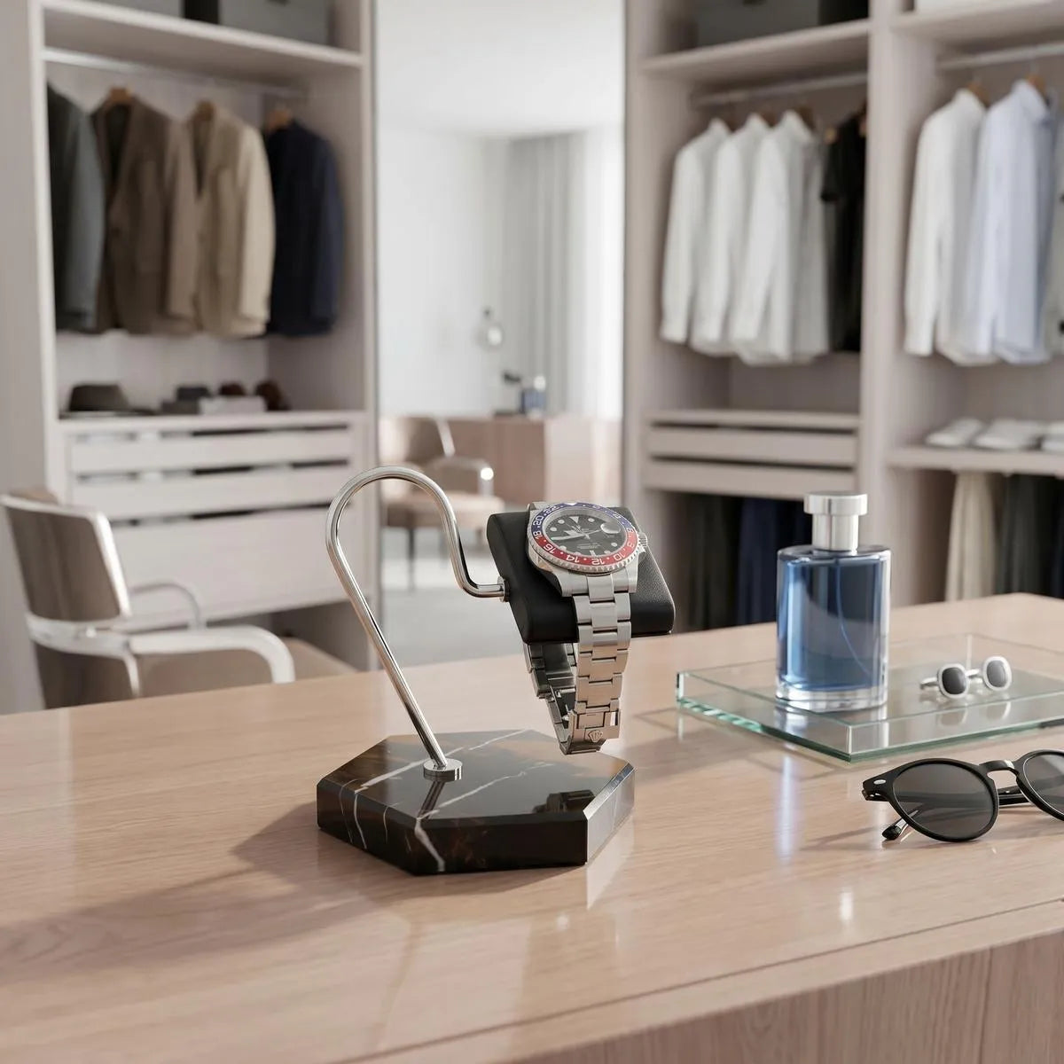 Close-up of Tempus watch stand with black marble base, brown veining, and black leather cushion in a bright luxurious walk-in dressing room.