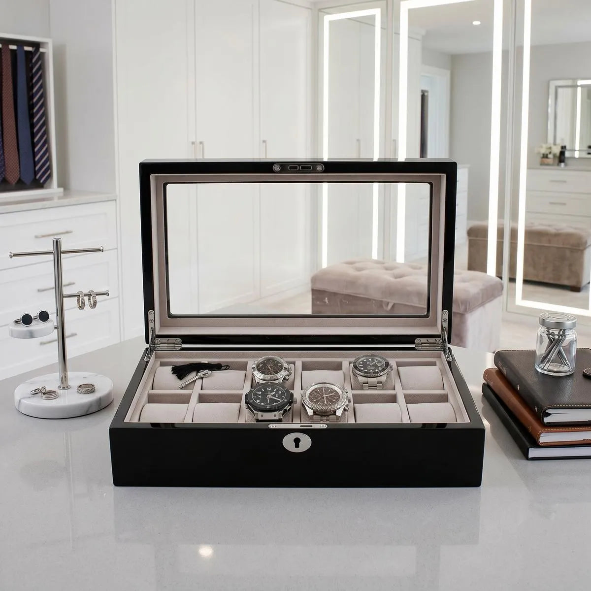 Elegantly designed 12-watch box in piano black gloss finish with grey interior lining, showcased in a bright luxury walk-in dressing room.