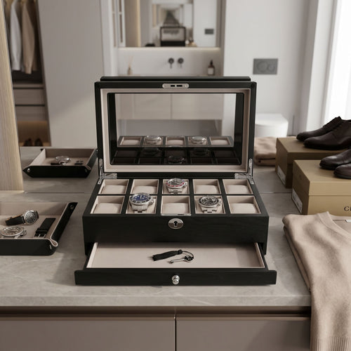 Close-up of a black oak veneer watch box with 10 cushioned slots and extra drawer in a bright luxurious walk-in dressing room.