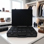 Close-up of black aluminium-look watch briefcase with lock and structured design in a luxurious walk-in dressing room.