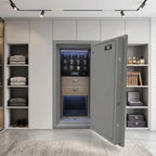High-resolution photo of a luxury watch winder safe embedded in sleek wall units within a bright, modern dressing room, highlighting its glossy black front and premium leather finish.