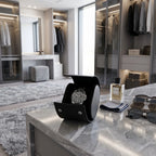 Full-body shot of black saffiano leather watch roll on a contemporary vanity in a plush dressing room scene.