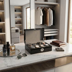 Full view of Tempus 8 watch box on dressing room vanity showing black finish, cushioned slots, and secure biometric lock, styled with luxury accessories.